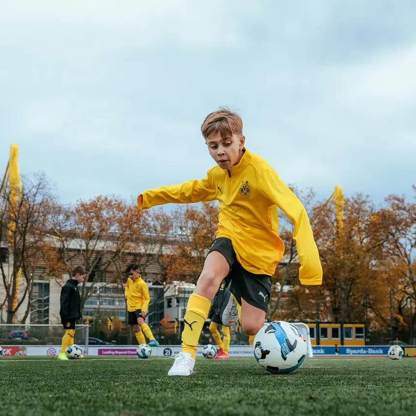 A boy playing football at a BVB Evonik Football Academy coaching session