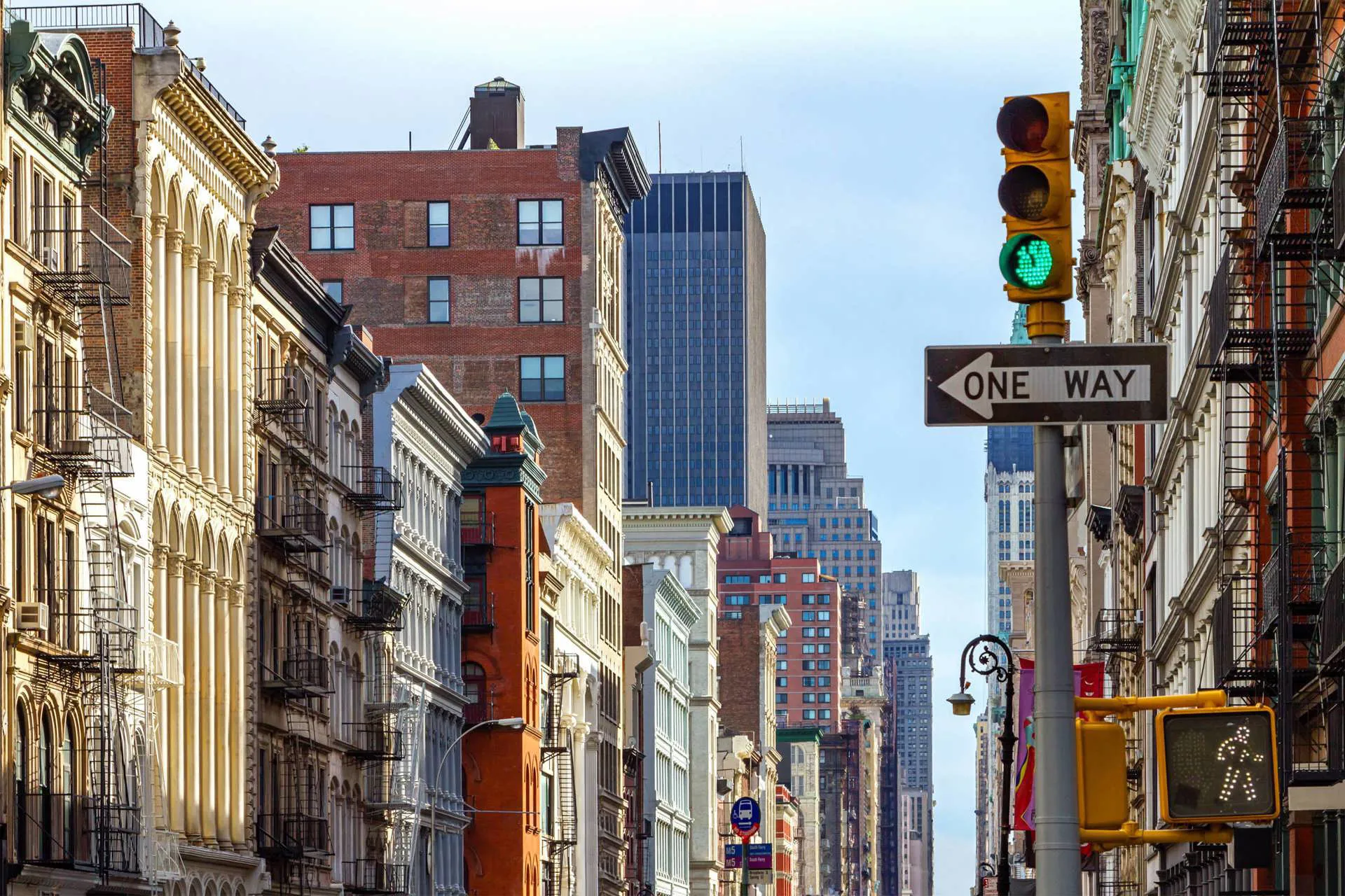 A street of apartments with a traffic light on green to the right in New York City, USA.