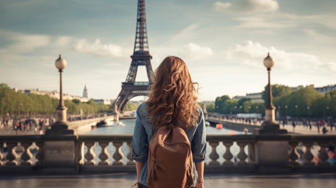 A  student standing in front of the Eiffel Tower whilst on an educational French language trip.
