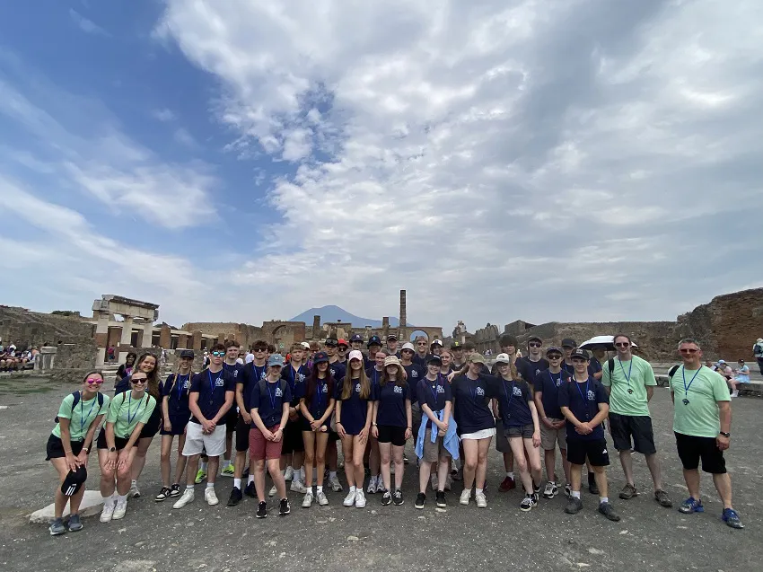 School group visiting Bay of Naples with Pompeii and Vesuvius in the background