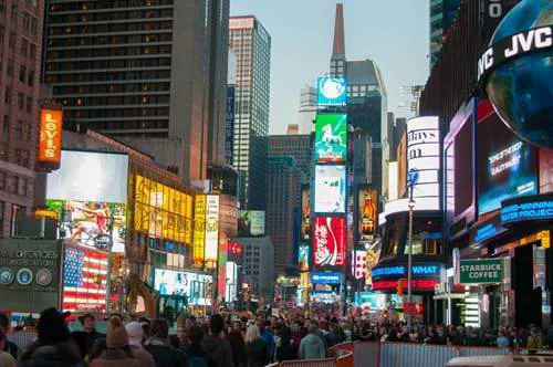 Times Square in New York City packed with people and neon billboards.